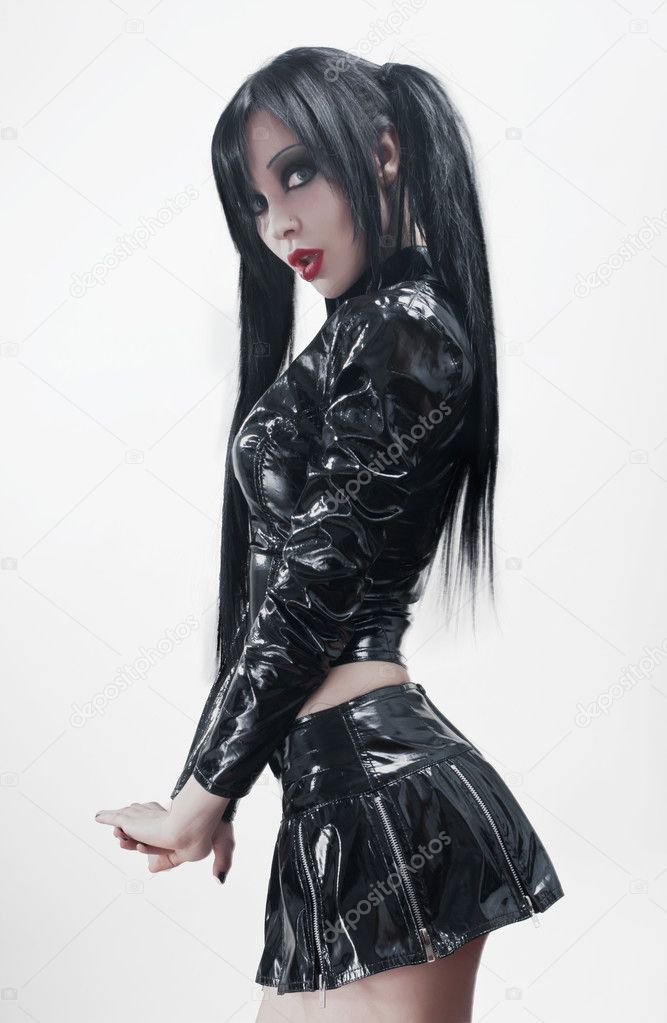 Gothic studio portrait of brunette sexy woman in black vinyl costume