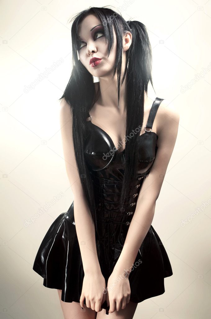Gothic studio portrait of brunette sexy woman in black latex dress