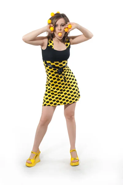 Молодая женщина в студии с желтыми шарами в волосах на белом фоне — стоковое фото
