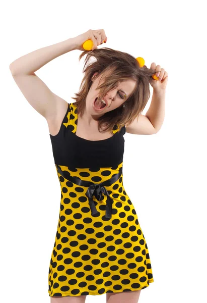 Mladá žena ve studiu s žluté kuličky v vlasy izolovaných na bílém pozadí — Stock fotografie