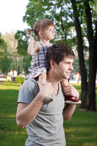 Pequena filha montando pai nos ombros — Fotografia de Stock