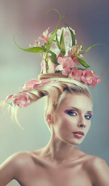 Vrouw met creatieve kapsel met bloemen — Stockfoto
