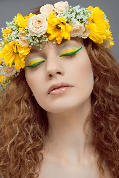 Studio portrait of young beautiful woman with flowers in hair — Stock Photo, Image