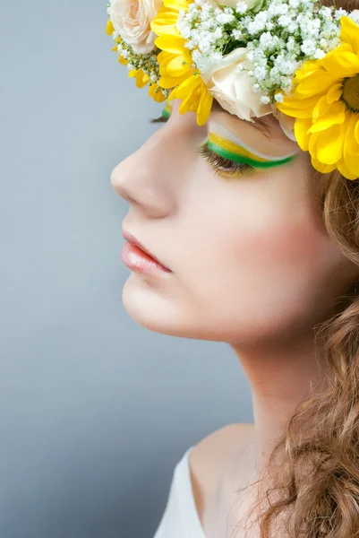 Studio portrait of young beautiful woman with flowers in hair — Stock Photo, Image