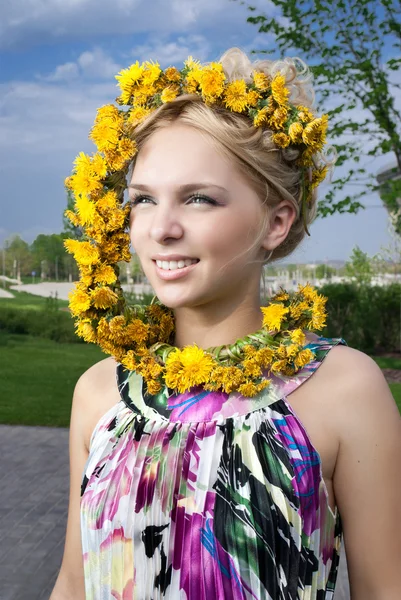 タンポポの花輪で若い女性の笑みを浮かべてください。 — ストック写真