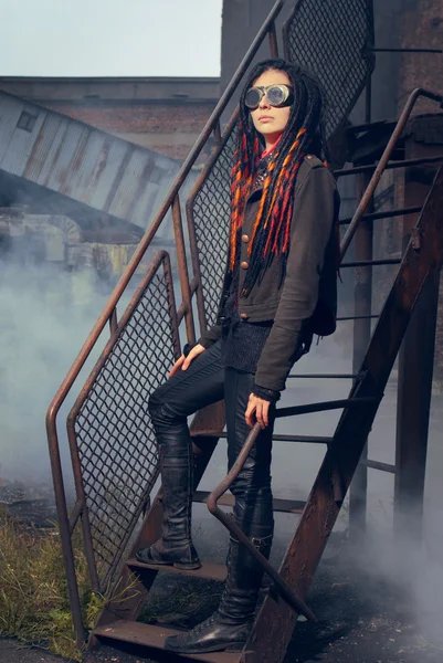 stock image Young woman in industrial style standing on stairs