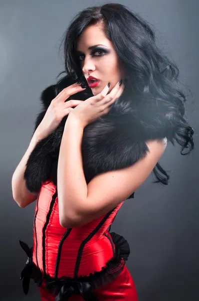 Sexy morena en piel de corsé rojo y pelo largo en estudio — Foto de Stock