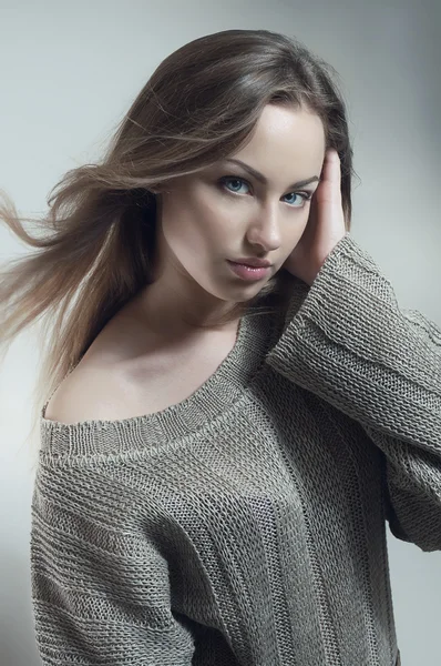 Молода жінка в в'язаному сірому светрі — стокове фото