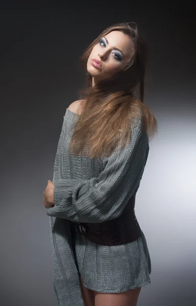 Retrato de uma menina em um suéter de malha cinza — Fotografia de Stock