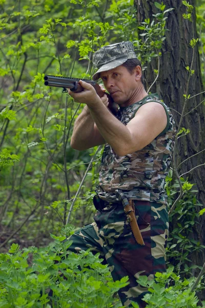 Jäger im Wald mit Waffe in der Hand — Stockfoto