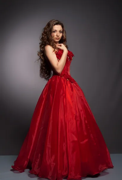 Mooie langharige vrouw in rode jurk — Stockfoto