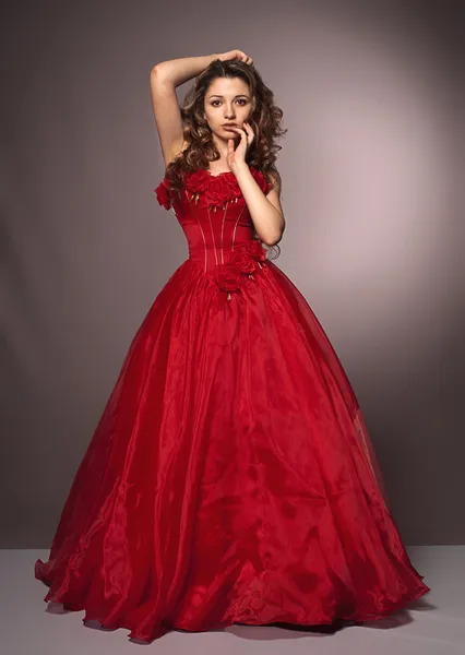 Güzel, uzun saçlı, kırmızı elbiseli kadın. — Stok fotoğraf