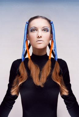 Studio portrait of young woman with blue and orange ribbons in hair clipart