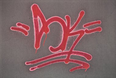 Red graffiti spray painted on a wall. clipart
