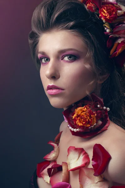 Schönheitsporträt mit roten Rosen und Blütenblättern — Stockfoto