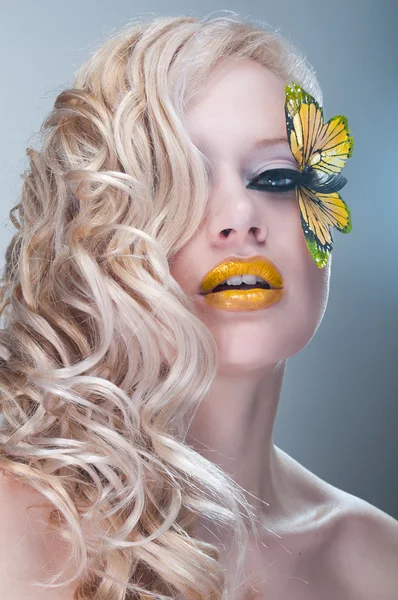 Kirpiklere üzerinde sarı kelebek ile sarışın kıvırcık kadın — Stok fotoğraf