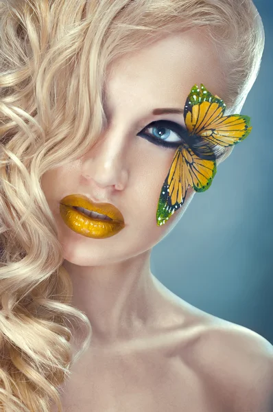 まつ毛に黄色の蝶と金髪の巻き毛女性 — ストック写真
