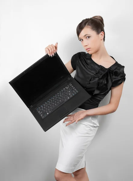 Studio ritratto di giovane donna in abito bianco e nero con computer portatile — Foto Stock