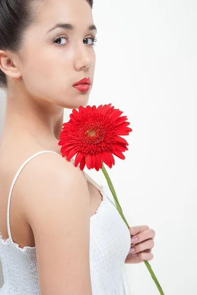 Młoda piękna kobieta w białej sukni z kwiatem — Zdjęcie stockowe