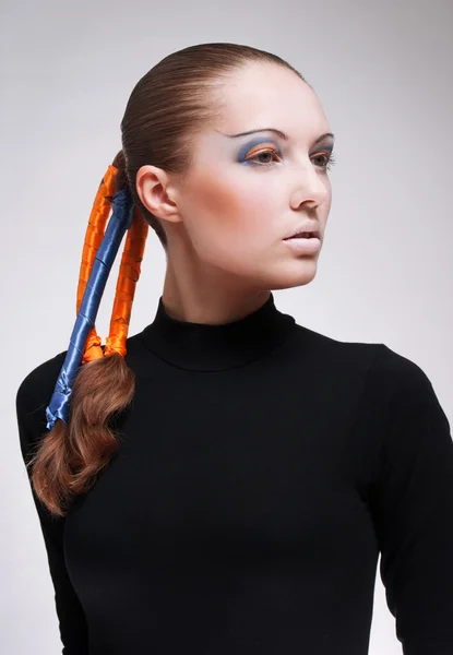 Студийный портрет молодой женщины с голубыми и оранжевыми лентами в волосах — стоковое фото