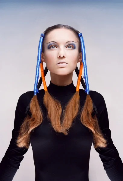 Portret młodej kobiety z niebieskie i pomarańczowe wstążki we włosach — Zdjęcie stockowe