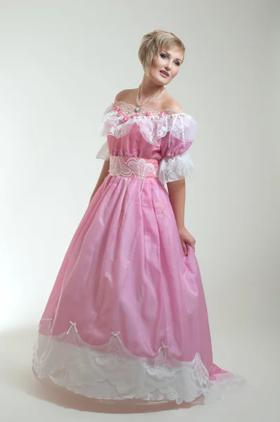 Blond kvinna i vacker lång rosa klänning — Stockfoto