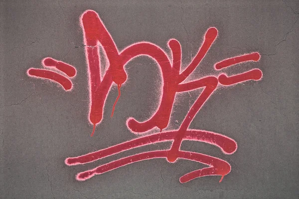 stock image Red graffiti spray painted on a wall.