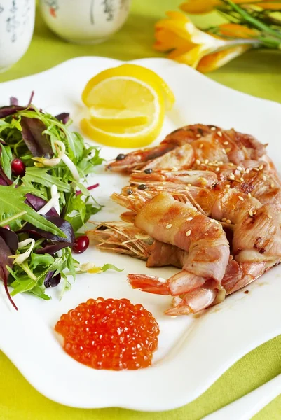 Shrimps baked in bacon, with salad and red caviar — Stock Photo, Image