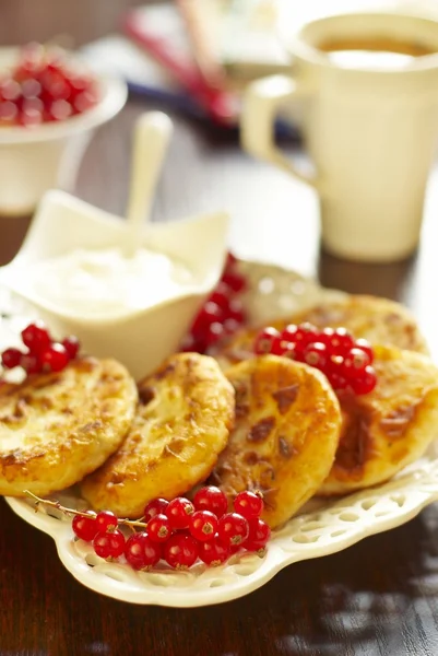 Cheese pancake with sour cream and red currant — Stock Photo, Image