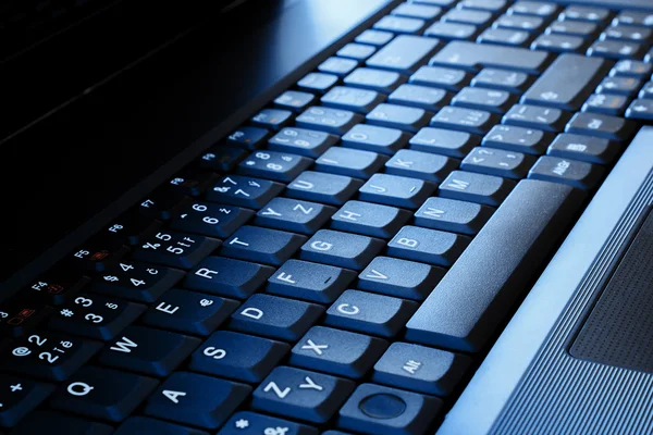Tastiera del computer portatile come tono di sfondo al blu — Foto Stock