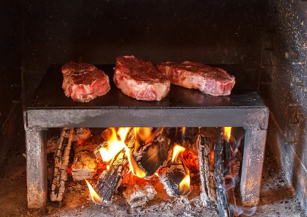 Steaks de porc se préparant sur le sur une assiette de pierre — Photo