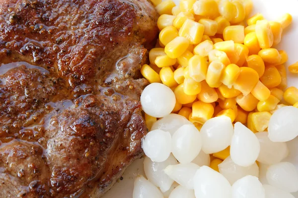 stock image Grilled pork steak with corn and small onions