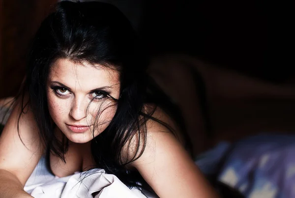 Krásná brunetka v posteli — Stock fotografie