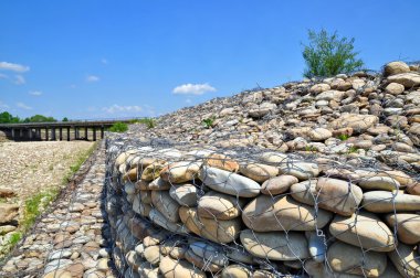 Gabion on the bank of the river clipart
