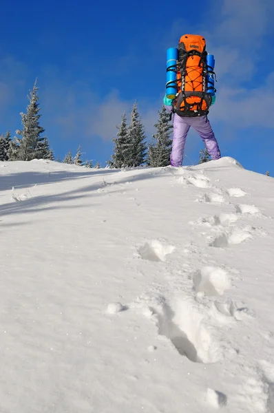 Turisten på en snö sluttning mot himlen — Stockfoto