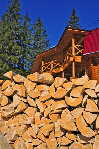 Fogo de madeira contra a casa — Fotografia de Stock