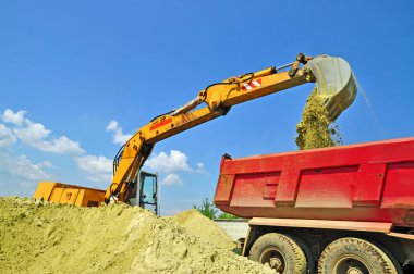 Sand loading in a dump-body truck clipart