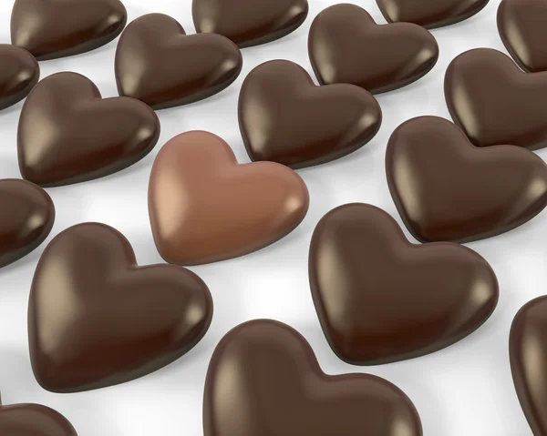 Herzförmige Milchschokolade zwischen dunklen Bonbons — Stockfoto