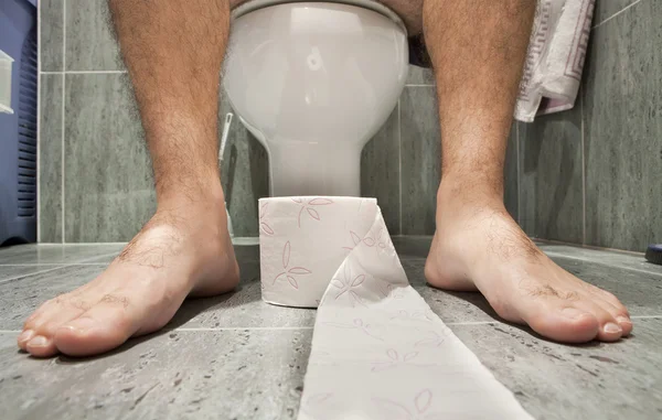 Een man zittend op toilet — Stockfoto
