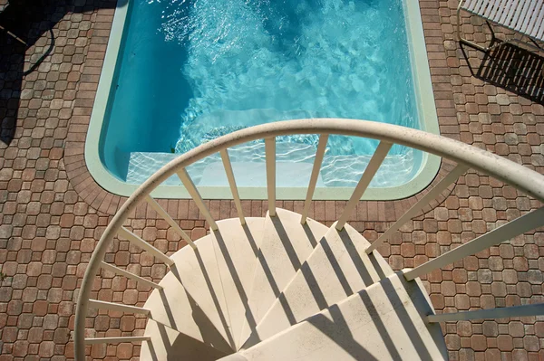 Looking down at spiral staircase and swimming pool — Stock Photo, Image