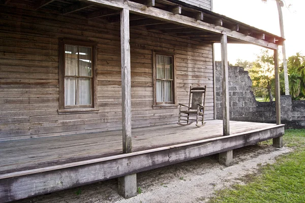 Casa de madeira velha com cadeira de balanço — Fotografia de Stock