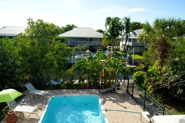 Piscina con vistas en los trópicos que muestra el canal y la casa — Foto de Stock