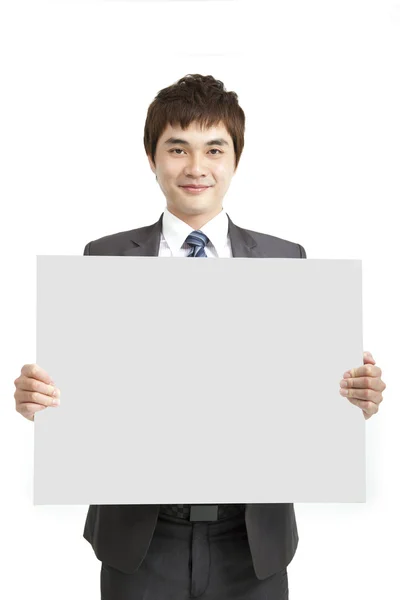 Smiling asian business man holding empty board — Stock Photo, Image