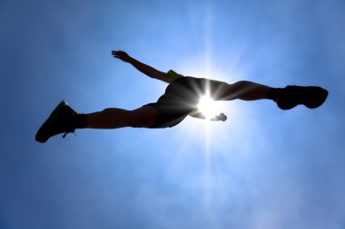 The Silhouette of runner acrossing sky with sunlight background clipart