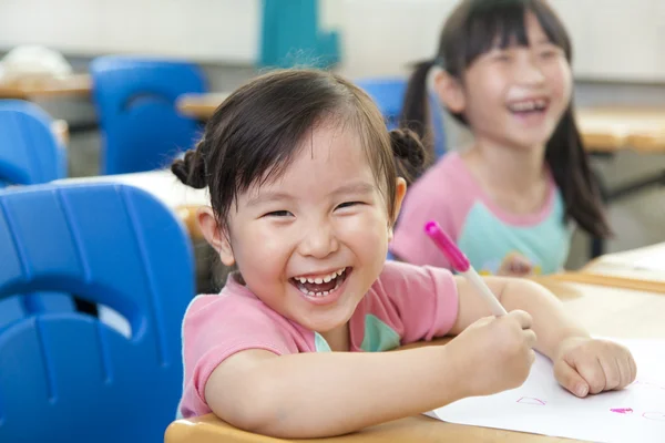 Glückliche kleine Mädchen im Klassenzimmer — Stockfoto