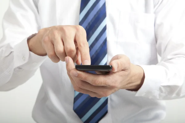 Üzletember érintőképernyős okostelefon a kezében — Stock Fotó