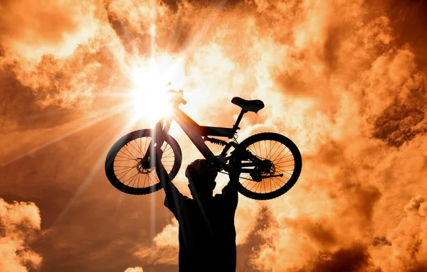 山地自行车手的剪影提出自行车与日落和云背景 — 图库照片