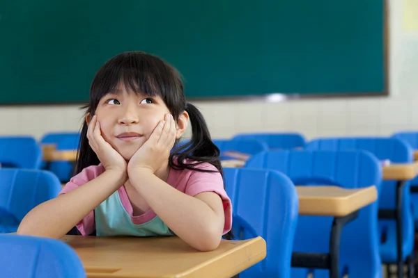 Klein meisje zijn denken in het klaslokaal van school — Stockfoto