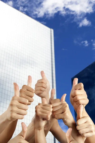 S hand with thumbs up in front of modern building — Stock Photo, Image