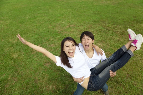 Happy asian couple on the grass — Stok Foto